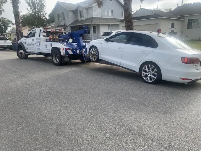 Mondragon Towing wrecker towing a sedan after a breakdown